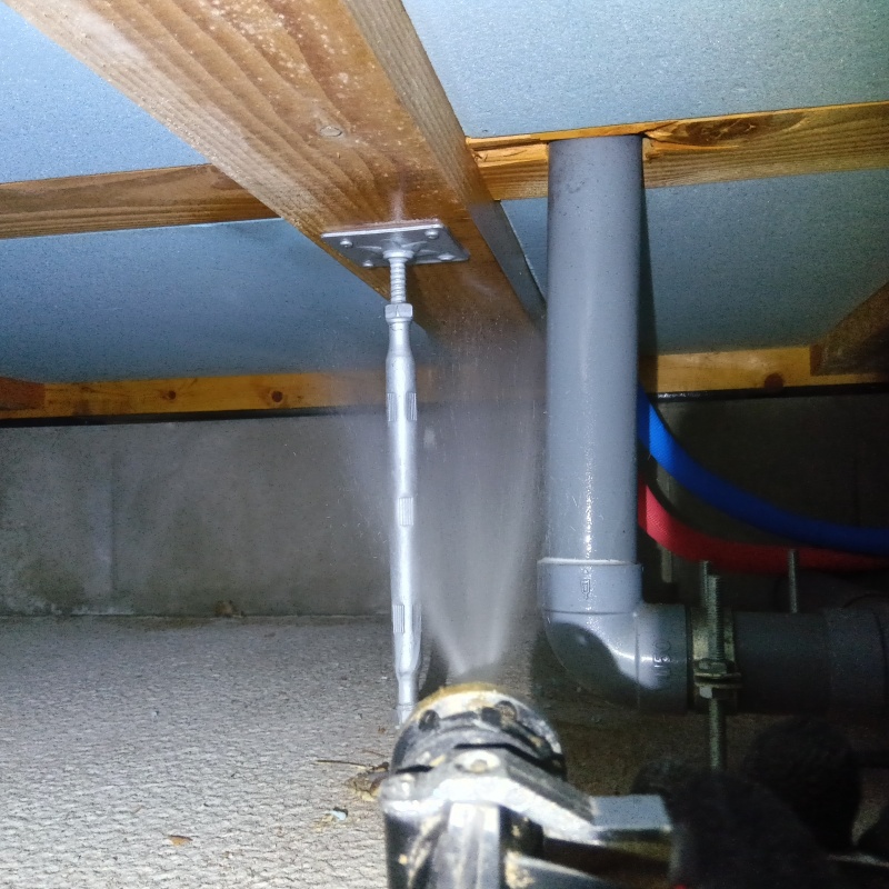 床下断熱材に防蟻剤を吹き付ける様子