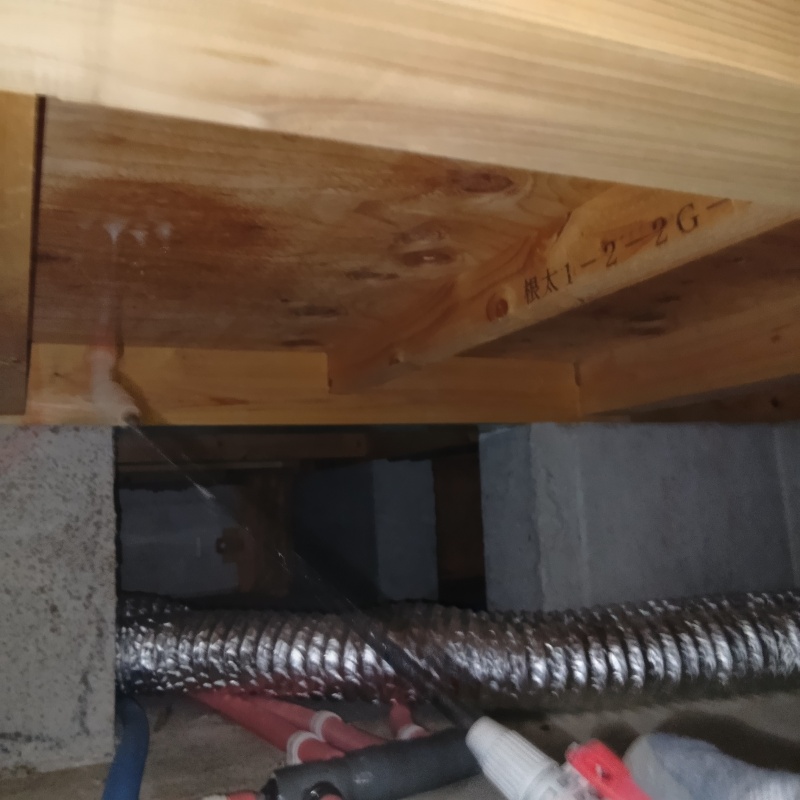 床下木材に防蟻剤を吹き付ける様子