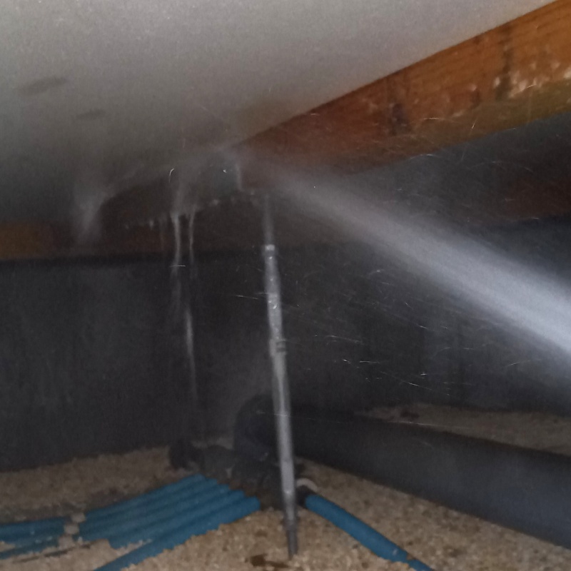 床下断熱材に防蟻剤を吹き付ける様子