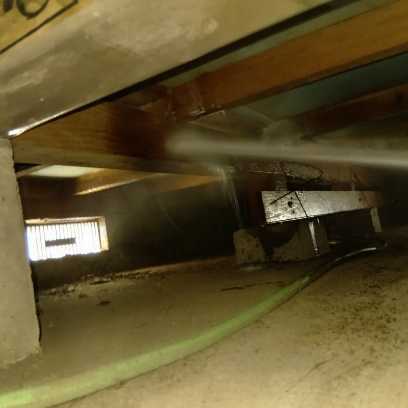 床下断熱材に防蟻剤を吹き付ける様子