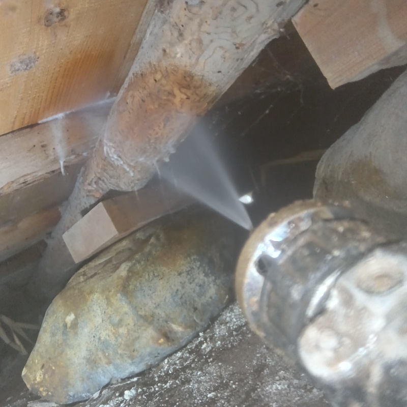 床下木材にシロアリ駆除剤を吹き付ける様子