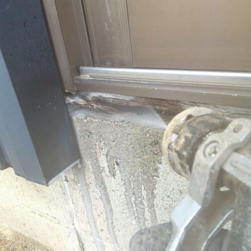 基礎まわりにシロアリ駆除剤を吹き付ける様子