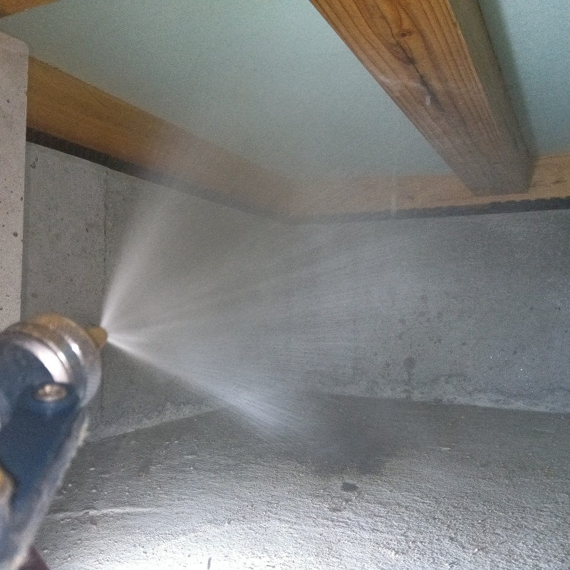 床下断熱材に防蟻剤を吹き付ける様子