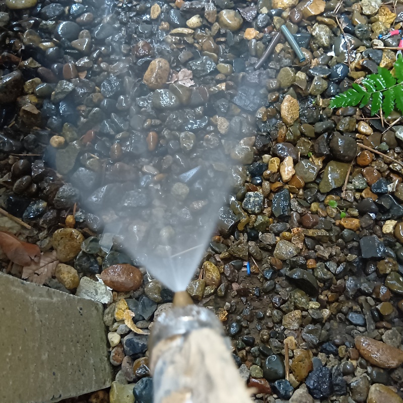 屋外の地面にシロアリ駆除剤を散布