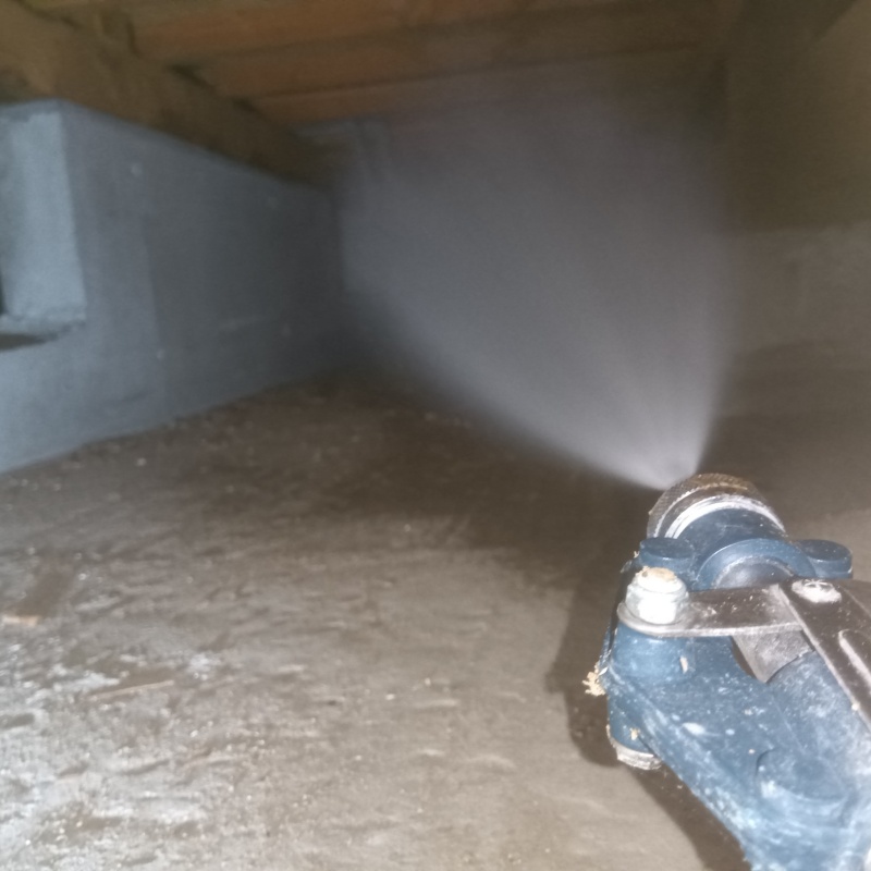 地面にシロアリ駆除剤を吹き付ける様子