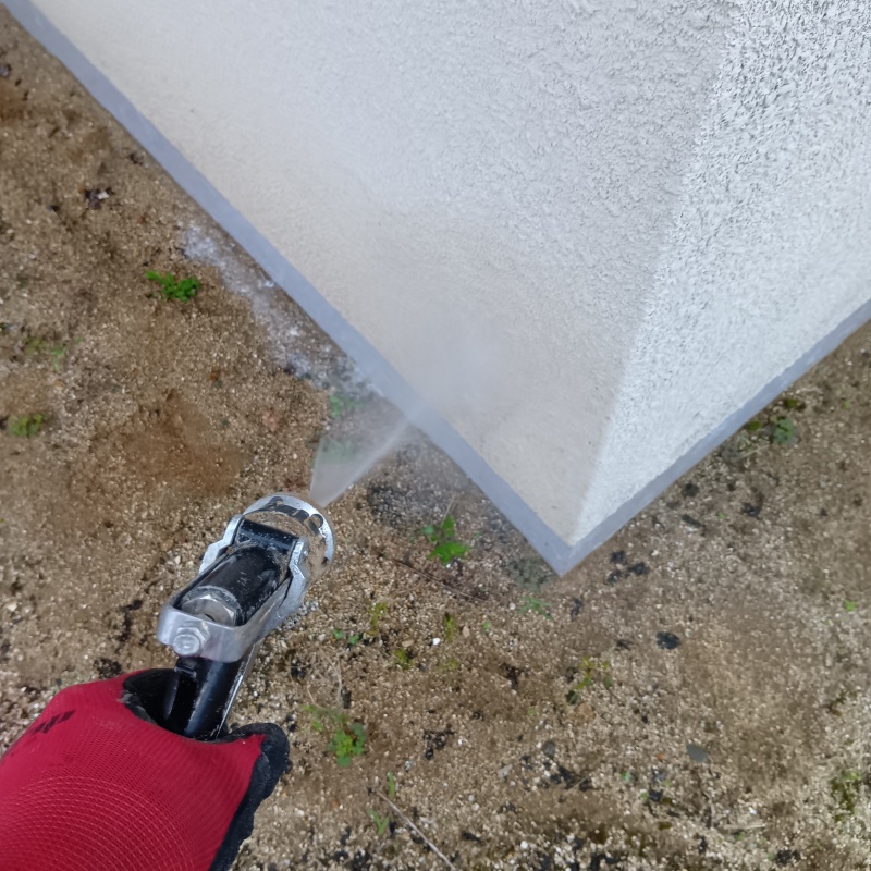 基礎まわりにシロアリ駆除剤を散布する様子