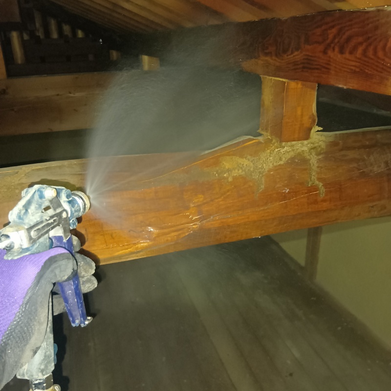 屋根裏の木材にシロアリ駆除剤を散布