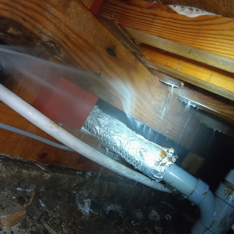 床下木材にシロアリ駆除剤を吹き付ける様子