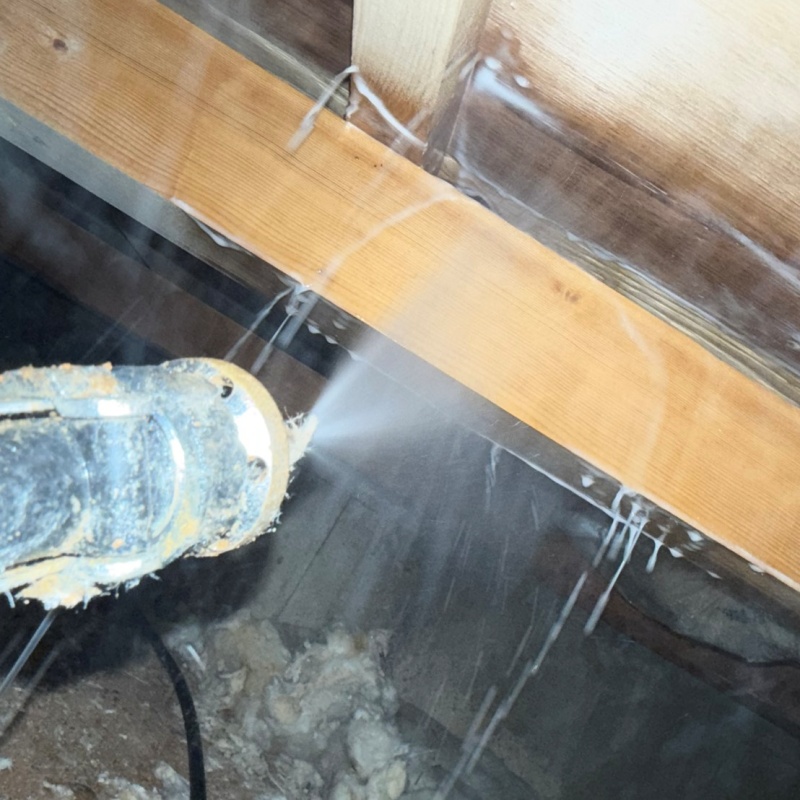 床下木材にシロアリ駆除剤を吹き付ける様子