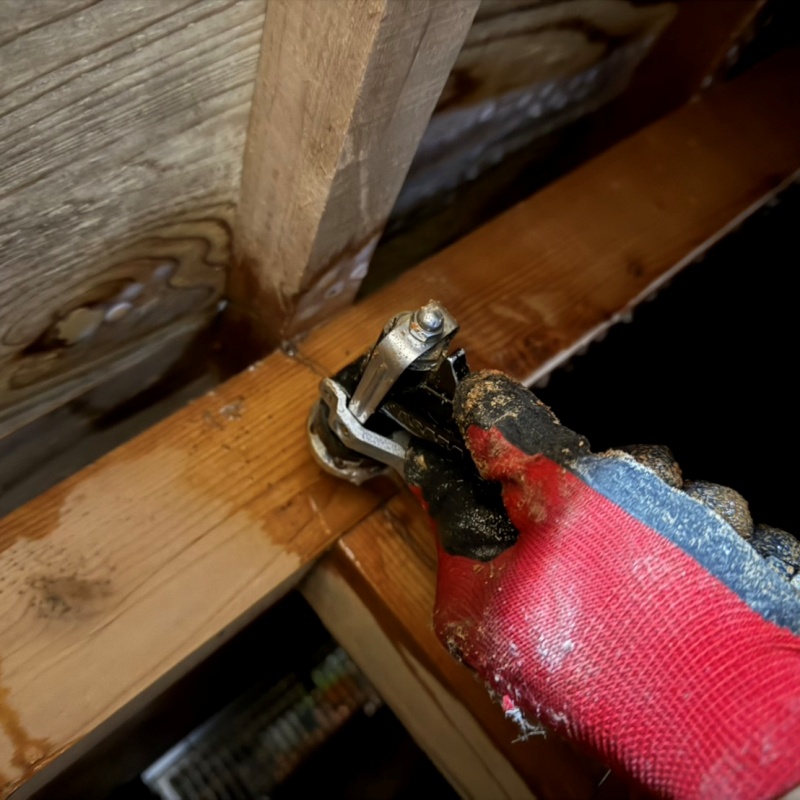 床下の木材に穴を開けてシロアリ駆除剤を注入