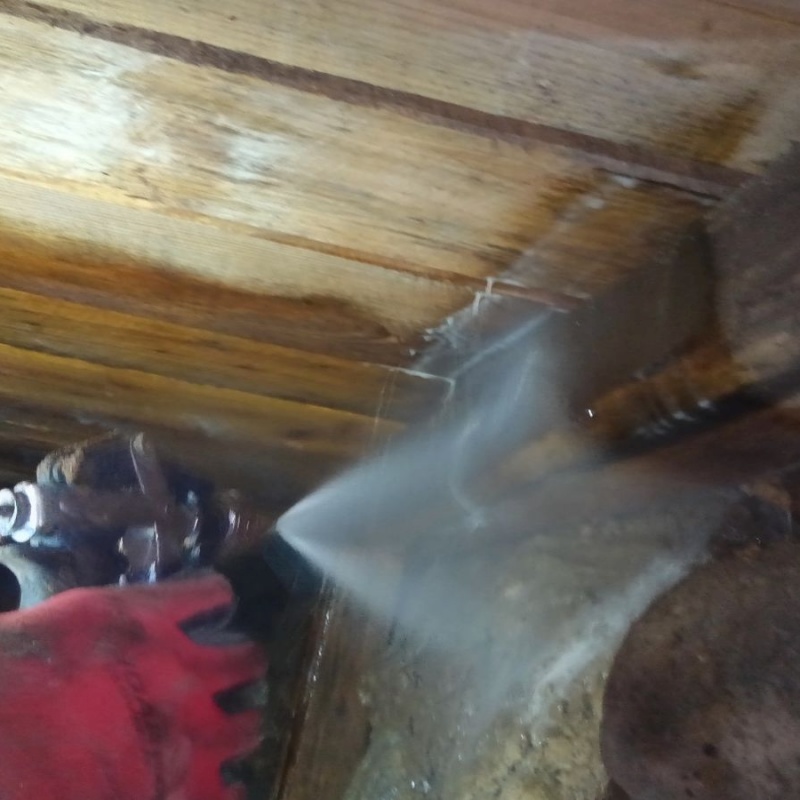 床下木材にシロアリ駆除剤を吹き付ける様子