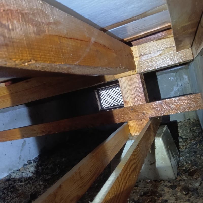 床下断熱材にシロアリ駆除剤を吹き付ける様子