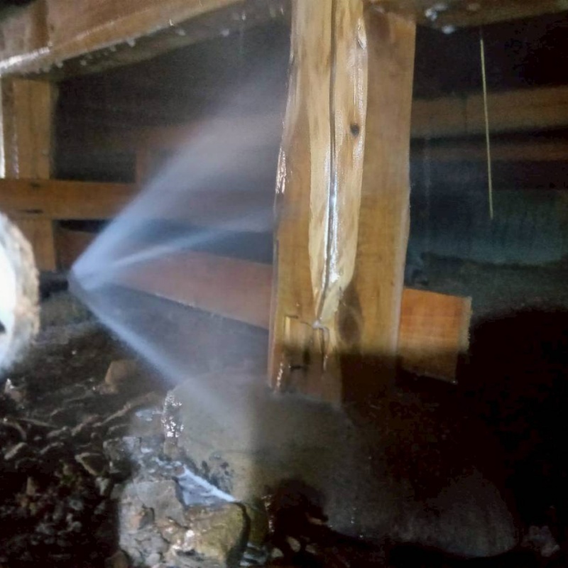 床下木材にシロアリ駆除剤を吹き付ける様子
