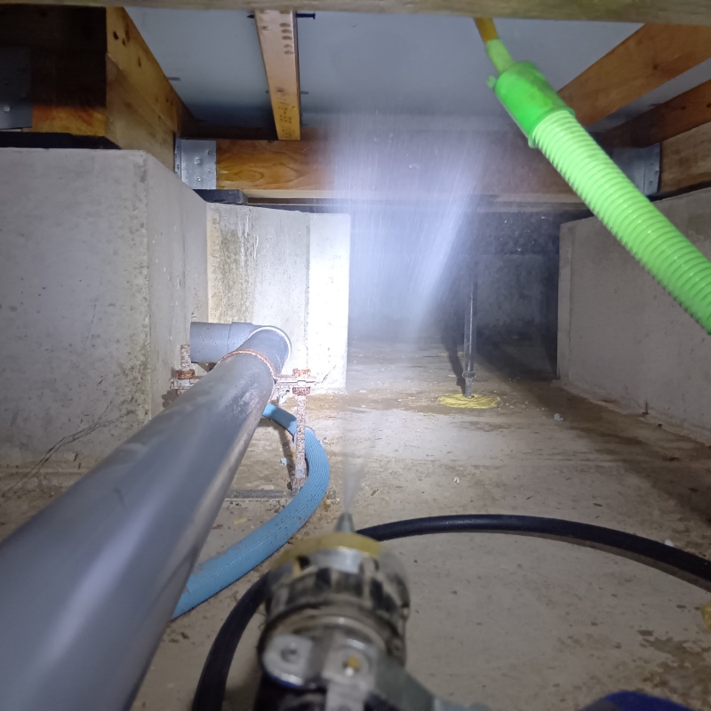 床下断熱材に防蟻剤を吹き付ける様子