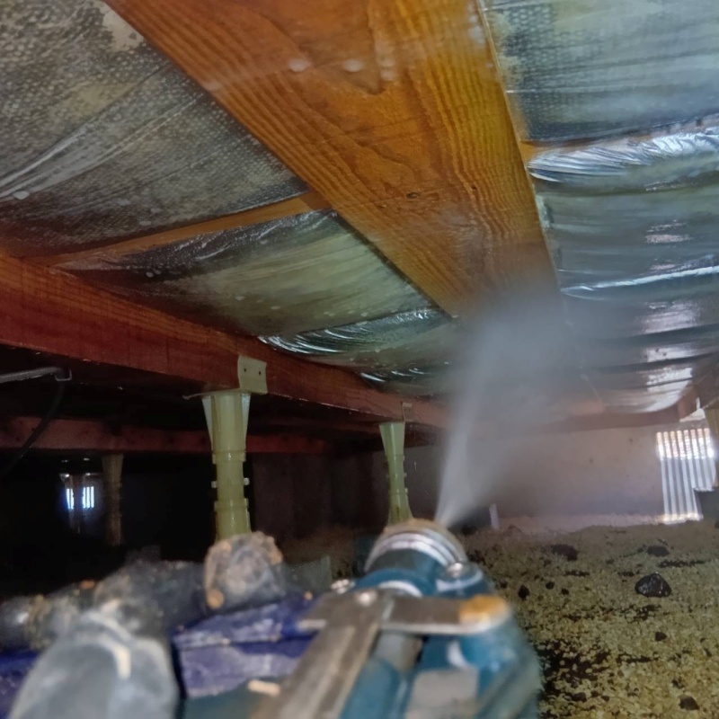 床下断熱材にシロアリ駆除剤を吹き付ける様子