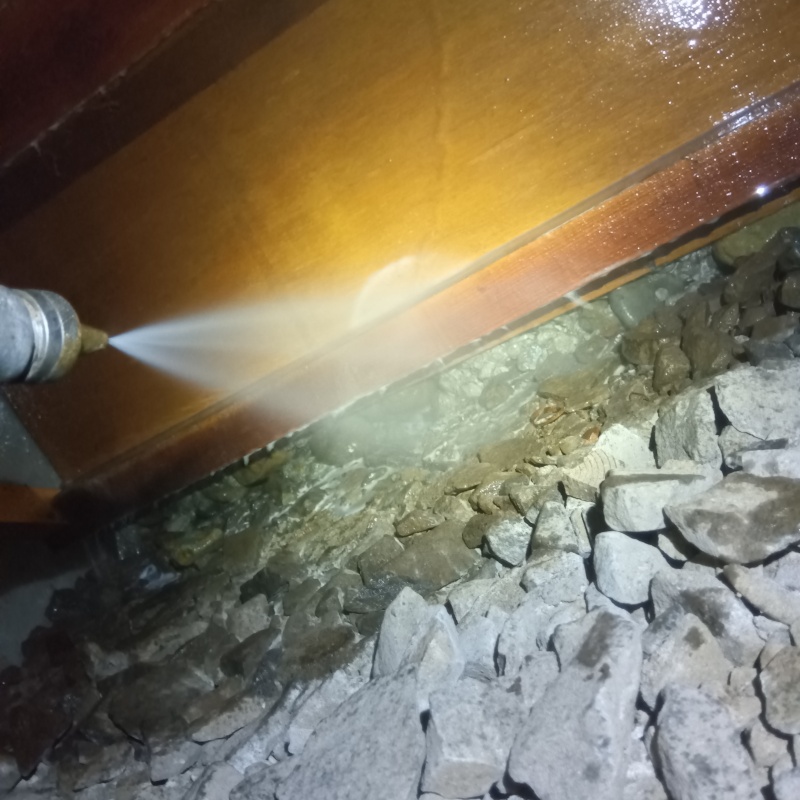 床下木材にシロアリ駆除剤を吹き付ける様子