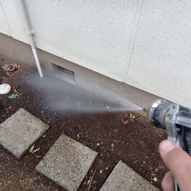 屋外の地面にシロアリ駆除剤を散布