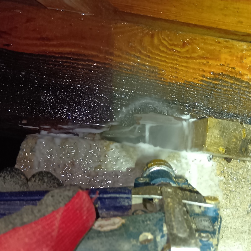 床下木材にシロアリ駆除剤を吹きつける様子