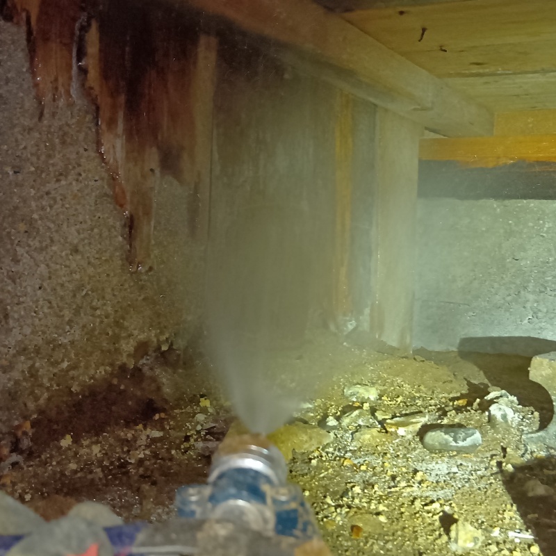 基礎にシロアリ駆除剤を吹きつける様子