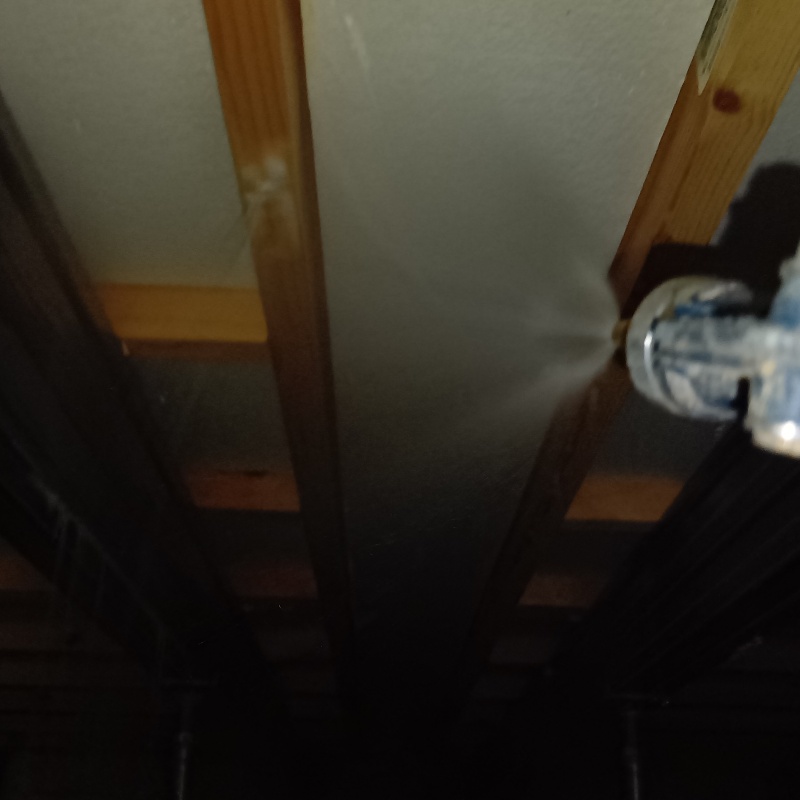 床下断熱材に防蟻剤を吹きつける様子