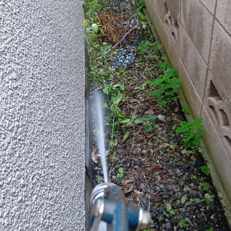 屋外の地面にシロアリ駆除剤を散布