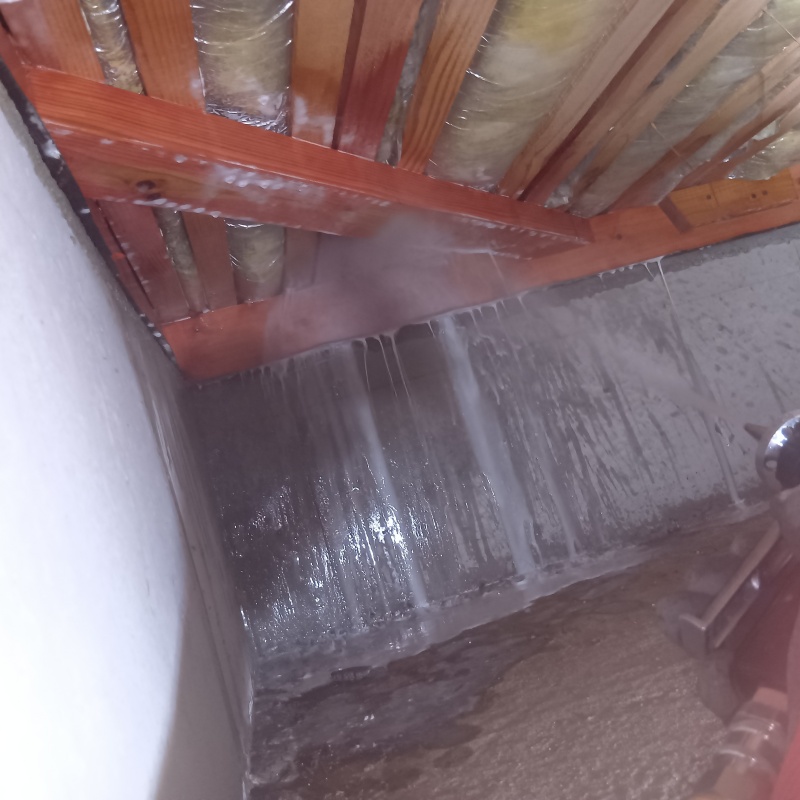 床下木材にシロアリ駆除剤を吹きつける様子