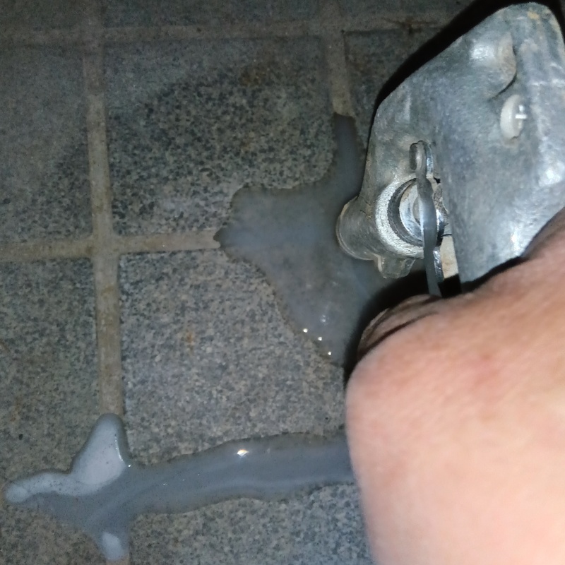 玄関床の目地に穴を開けてシロアリ駆除剤を注入している様子