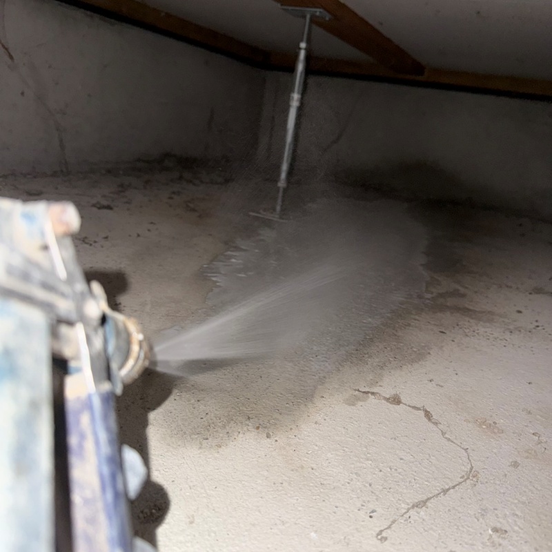 地面にシロアリ駆除剤を吹きつける様子