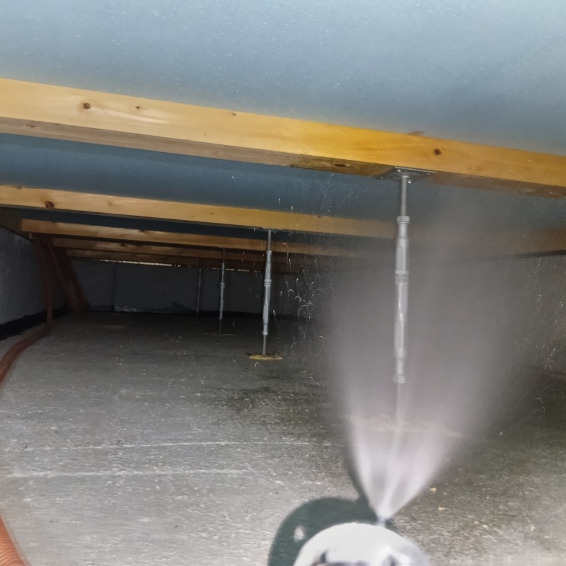 床下断熱材に防蟻剤を吹き付ける様子