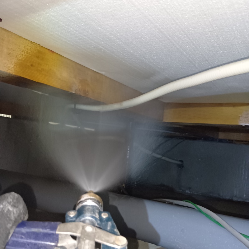 床下断熱材にシロアリ駆除剤を吹き付ける様子