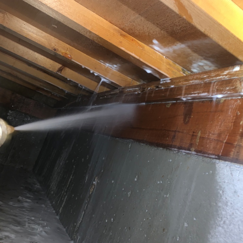 床下木材にシロアリ駆除剤を吹き付ける様子