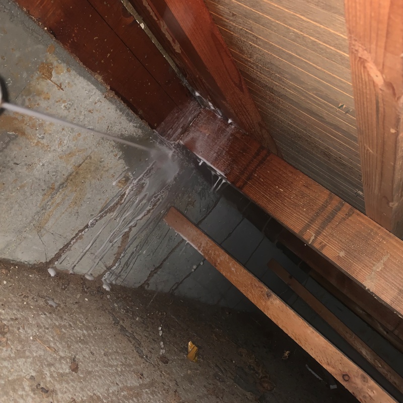 基礎にシロアリ駆除剤を吹き付ける様子