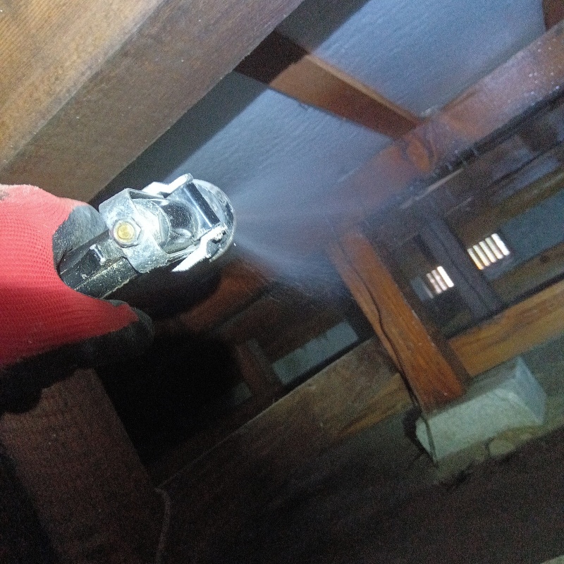 床下断熱材にシロアリ駆除剤を吹き付ける様子