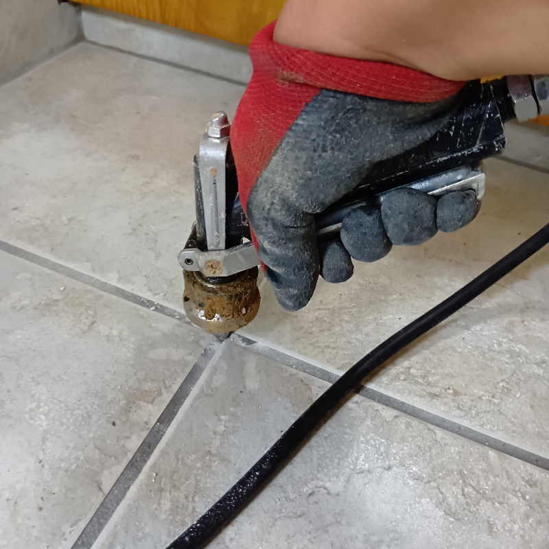 玄関床の目地に穴を開けてシロアリ駆除剤を注入