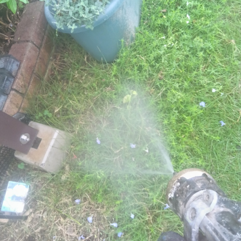 建物外周の土壌に防蟻剤を吹きつける様子