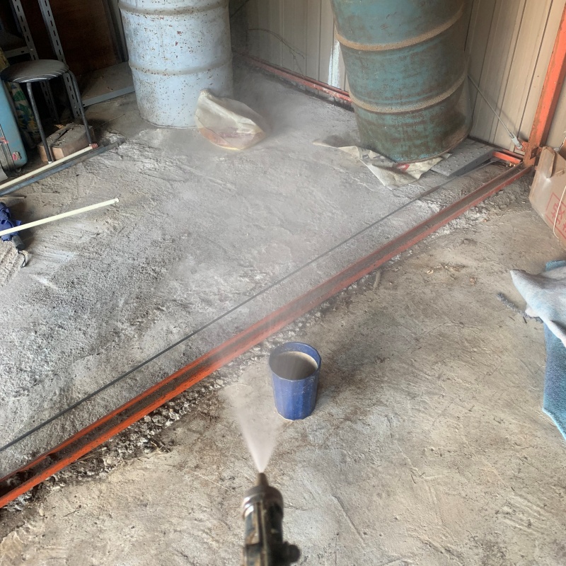 地面にシロアリ駆除剤を吹きつける様子