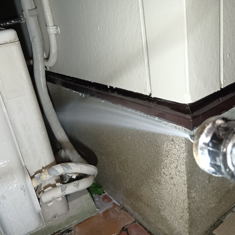 屋外の配管まわりにシロアリ駆除剤を散布