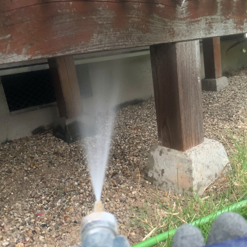 ウッドデッキの足元にシロアリ駆除剤を散布