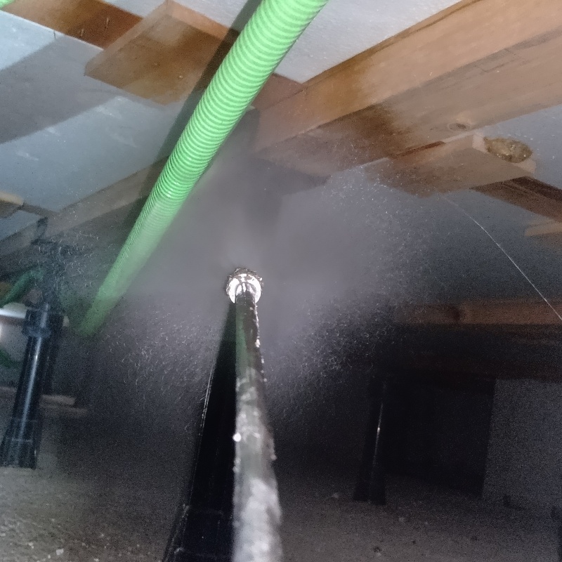 床下木材に防蟻剤を吹きつける様子