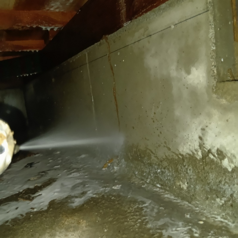 基礎にシロアリ駆除剤を吹きつける様子