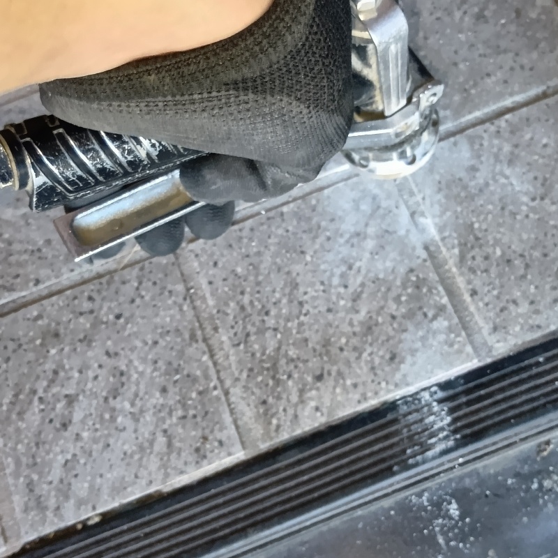 玄関床の目地から防蟻剤を注入する様子