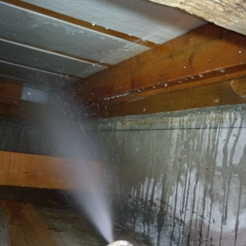 床下断熱材にシロアリ駆除剤を散布する様子