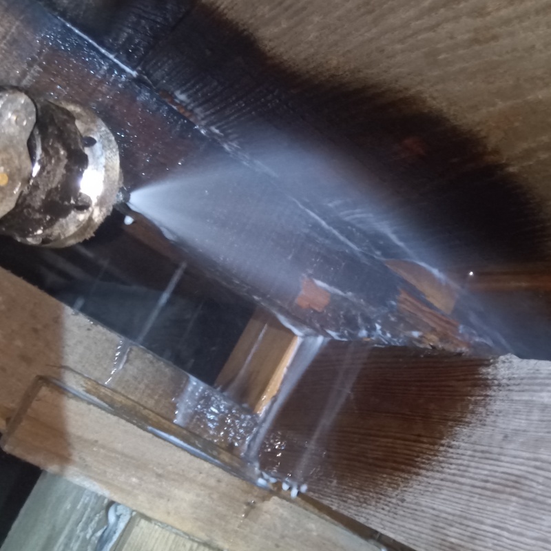 床下木材にシロアリ駆除剤を吹き付ける様子