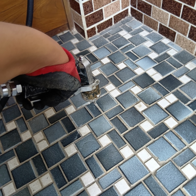 玄関先のタイルの目地からシロアリ駆除剤を注入