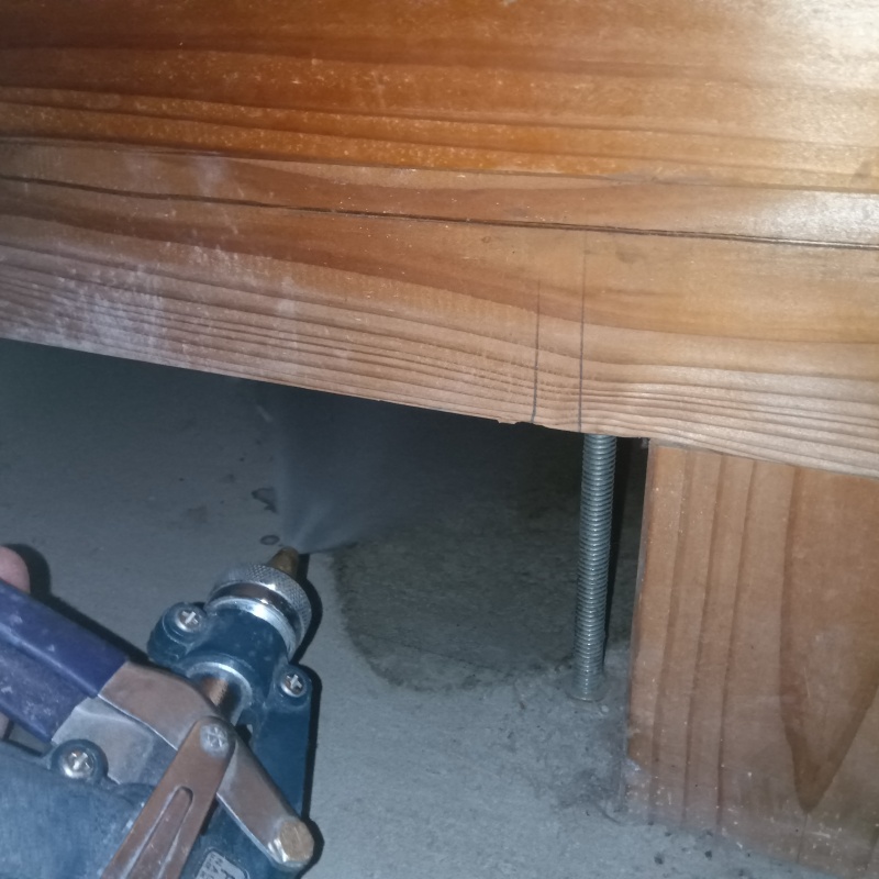 地面にシロアリ駆除剤を吹き付ける様子