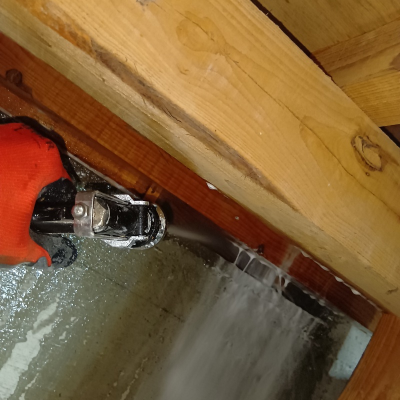 床下木材にシロアリ駆除剤を吹きつける様子