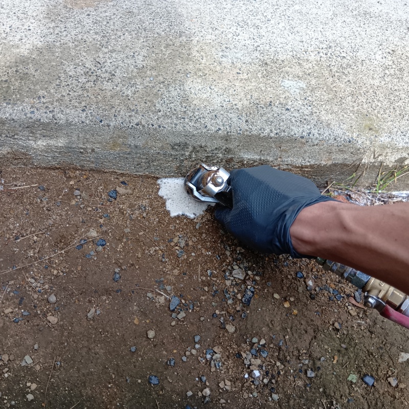 屋外の地面にシロアリ駆除剤を散布