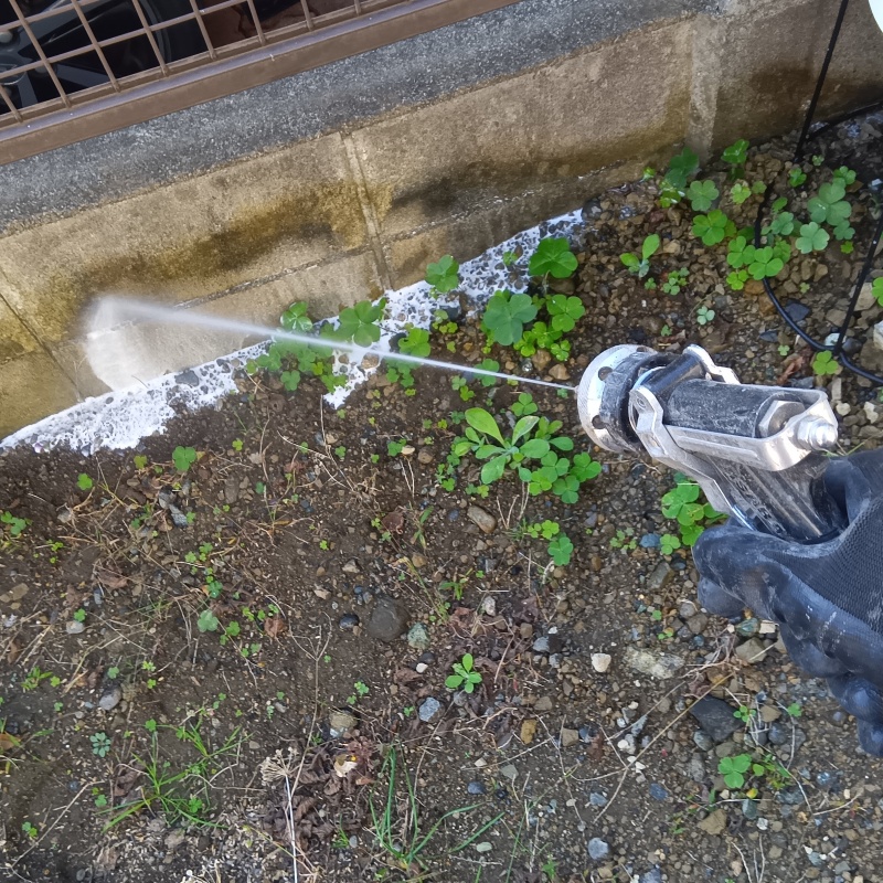 屋外の地面にシロアリ駆除剤を散布