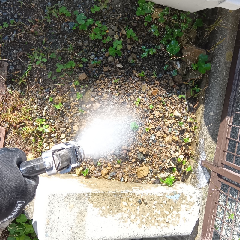 屋外の地面にシロアリ駆除剤を散布