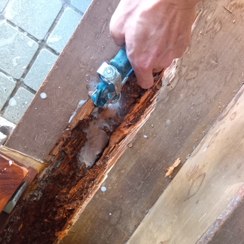 腐食した木材にシロアリ駆除剤を散布